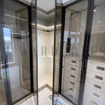 Bespoke dressing room with Italian brown tinted glass doors and the island