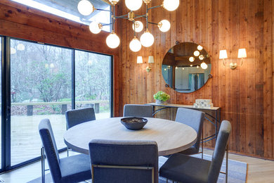 Example of a trendy light wood floor and beige floor dining room design in New York with brown walls