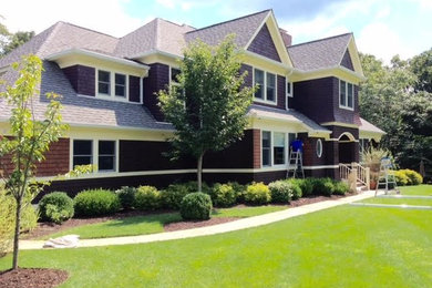 Inspiration for a large timeless brown two-story wood exterior home remodel in New York with a shingle roof
