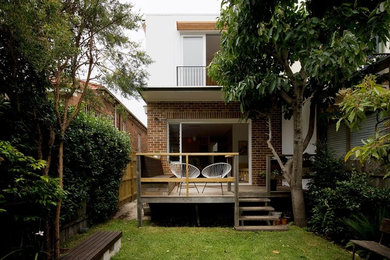 Midcentury two-storey white exterior in Sydney with wood siding.