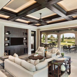 Geräumiges, Offenes Mediterranes Wohnzimmer mit beiger Wandfarbe, Marmorboden, Wand-TV und beigem Boden in Miami