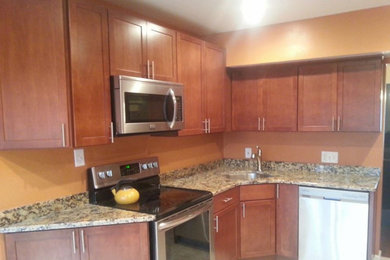 Example of a mid-sized transitional l-shaped kitchen design in Baltimore with an undermount sink, shaker cabinets, medium tone wood cabinets, granite countertops, stainless steel appliances and no island