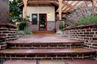 Inspiration for a backyard stone patio remodel in Denver with a pergola