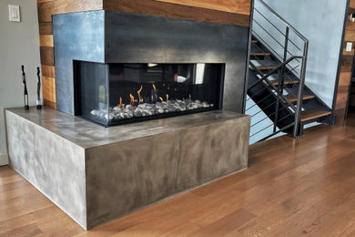 Living room - mid-sized modern living room idea in Seattle with a corner fireplace and a concrete fireplace