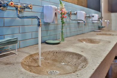 Shabby-Look Gästetoilette mit blauen Fliesen, Betonboden und Beton-Waschbecken/Waschtisch in Sonstige