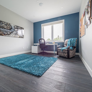 エドモントンの中サイズのモダンスタイルのおしゃれな書斎 (青い壁、無垢フローリング、自立型机、グレーの床) の写真