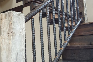 Large urban wooden l-shaped metal railing staircase photo in Other with wooden risers