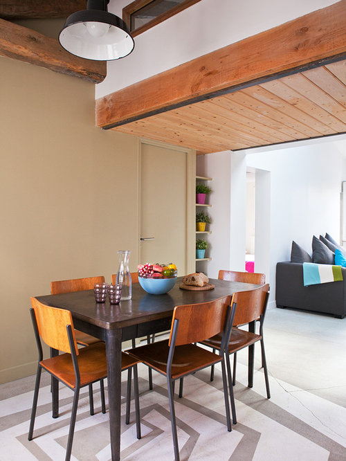Idée de décoration pour une salle à manger ouverte sur le salon design de taille moyenne avec un mur beige et béton au sol.