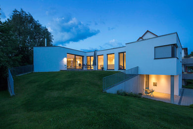 Inspiration for a contemporary two-storey white exterior in Stuttgart with a flat roof.