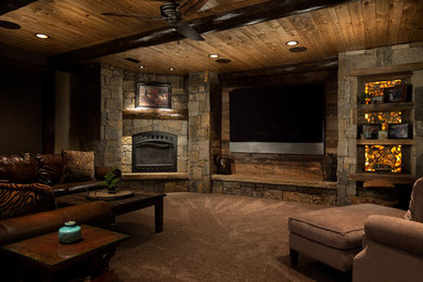 Example of a large mountain style walk-out carpeted basement design in Kansas City with beige walls, a standard fireplace and a stone fireplace