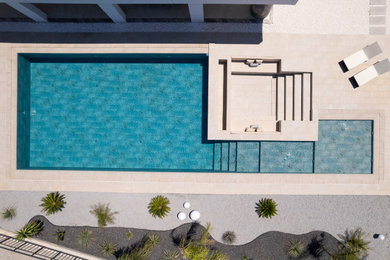 Backyard tile and rectangular pool photo in Other