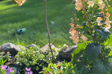 This is an example of a mid-sized partial sun front yard river rock landscaping in Other.
