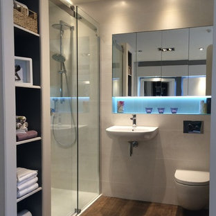 Idee per una stanza da bagno minimalista con lavabo sospeso, top in vetro, doccia alcova, WC sospeso, piastrelle beige, piastrelle in ceramica, pareti beige e pavimento con piastrelle in ceramica