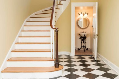 Staircase - large traditional wooden curved wood railing staircase idea in Baltimore with painted risers