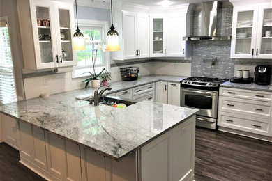Mid-sized elegant l-shaped medium tone wood floor and brown floor kitchen photo in Other with brown cabinets and stainless steel appliances