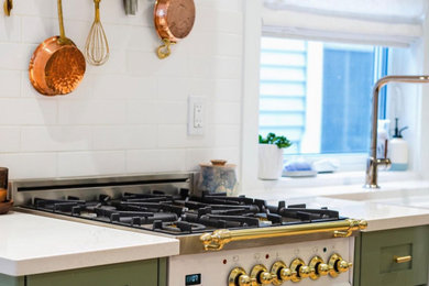 Cette photo montre une cuisine américaine moderne avec des portes de placards vertess, une crédence blanche, une crédence en brique, un électroménager blanc et un plan de travail blanc.