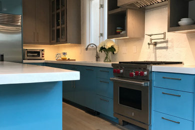 Kitchen - large contemporary l-shaped light wood floor and beige floor kitchen idea in Houston with an undermount sink, flat-panel cabinets, blue cabinets, white backsplash, ceramic backsplash, stainless steel appliances, an island and white countertops