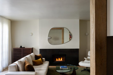 Стильный дизайн: изолированная гостиная комната среднего размера в стиле модернизм с светлым паркетным полом, стандартным камином и фасадом камина из металла - последний тренд