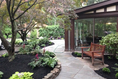 Large elegant backyard patio photo in New York with no cover