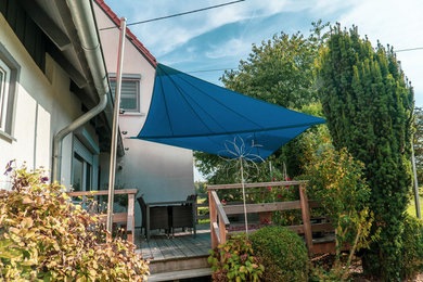 Mid-sized beach style deck in Stuttgart with an awning.