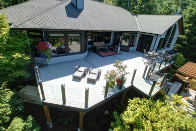 This is an example of a large contemporary backyard deck in Seattle with an outdoor kitchen and a pergola.