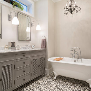 Mid-sized transitional master cement tile floor and multicolored floor claw-foot bathtub photo in Chicago with gray cabinets, gray walls, an undermount sink, marble countertops, louvered cabinets and gray countertops