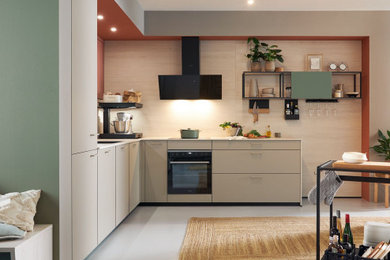 Diseño de cocina minimalista grande con puertas de armario grises y electrodomésticos negros