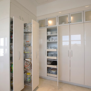 Aménagement d'une très grande arrière-cuisine contemporaine avec un placard à porte plane et des portes de placard blanches.