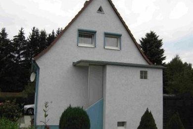 Kleines Modernes Haus mit weißer Fassadenfarbe und Satteldach in Sonstige