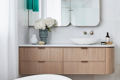 Photo of a large transitional master bathroom in Sydney with beaded inset cabinets, light wood cabinets, a freestanding tub, an open shower, a one-piece toilet, white tile, marble, white walls, marble floors, a vessel sink, engineered quartz benchtops, pink floor, an open shower, white benchtops, a shower seat, a single vanity and a floating vanity.