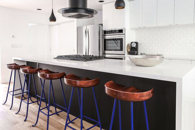 Large danish light wood floor kitchen photo in Los Angeles with a drop-in sink, quartz countertops, white backsplash, ceramic backsplash, stainless steel appliances, an island and white countertops
