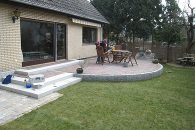 Große Klassische Terrasse hinter dem Haus mit Kübelpflanzen und Markisen in Berlin