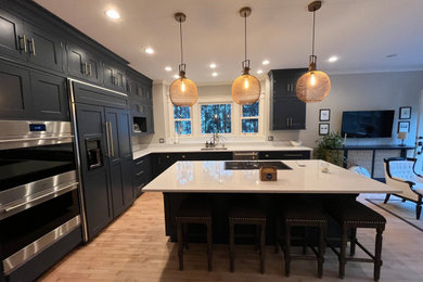 Large l-shaped eat-in kitchen photo in Chicago with blue cabinets, quartz countertops, stainless steel appliances, an island and white countertops