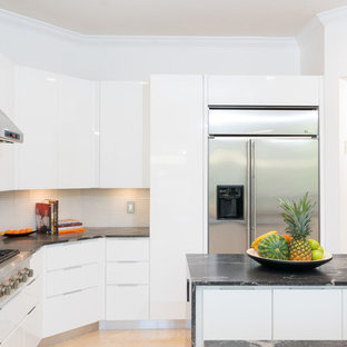 Large modern kitchen pantry photos - Kitchen pantry - large modern travertine floor kitchen pantry idea in Miami with white cabinets, granite countertops, gray backsplash, porcelain backsplash, stainless steel appliances and two islands