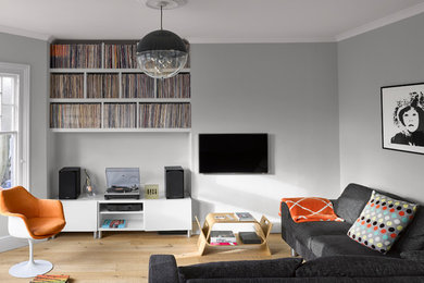 Design ideas for a medium sized contemporary games room in London with grey walls, no fireplace, a wall mounted tv, beige floors and light hardwood flooring.