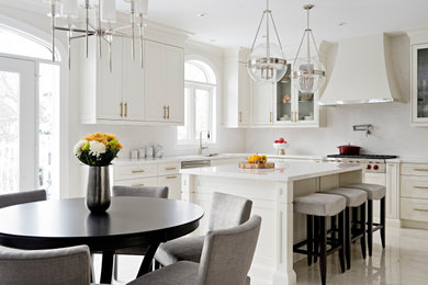 Inspiration for a transitional l-shaped eat-in kitchen in Toronto with an undermount sink, recessed-panel cabinets, white cabinets, white splashback, with island, beige floor and white benchtop.
