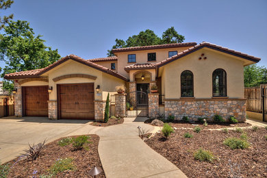 Photo of a mediterranean two-storey beige exterior in Other with mixed siding.