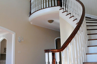 Inspiration for a mid-sized traditional wood curved staircase in Austin with painted wood risers.