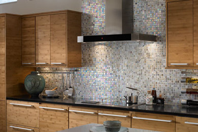 Large modern single-wall kitchen in Los Angeles with flat-panel cabinets, light wood cabinets, granite benchtops, multi-coloured splashback, mosaic tile splashback and with island.