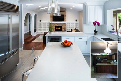 Modern inredning av ett kök, med vita skåp, bänkskiva i kvartsit och travertin golv