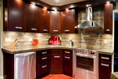 This is an example of a mid-sized contemporary l-shaped separate kitchen in Other with a double-bowl sink, flat-panel cabinets, dark wood cabinets, granite benchtops, multi-coloured splashback, slate splashback, stainless steel appliances, medium hardwood floors, with island, brown floor and grey benchtop.