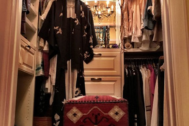 Example of a mid-sized cottage women's walk-in closet design in Los Angeles with raised-panel cabinets and white cabinets
