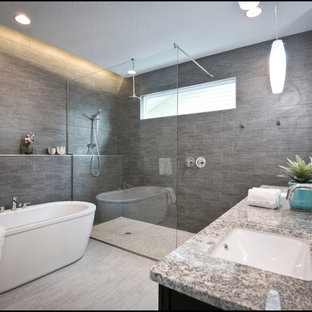 Esempio di una grande stanza da bagno padronale minimalista con lavabo sottopiano, vasca freestanding, top in granito, doccia a filo pavimento, piastrelle bianche, piastrelle in ceramica, pavimento con piastrelle in ceramica, ante in legno bruno e pareti grigie