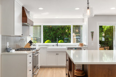 Eat-in kitchen - cottage u-shaped light wood floor eat-in kitchen idea in Seattle with an island, a farmhouse sink, white cabinets, quartzite countertops and white countertops