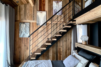 Réalisation d'une grande chambre parentale chalet en bois avec parquet clair et un plafond en bois.