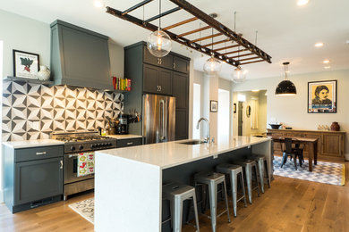 Example of a large transitional galley medium tone wood floor and brown floor kitchen design in DC Metro with an undermount sink, shaker cabinets, gray cabinets, multicolored backsplash, stainless steel appliances, an island, quartz countertops and cement tile backsplash