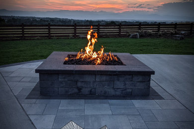 This is an example of a large contemporary back patio in Denver with a fire feature and concrete paving.