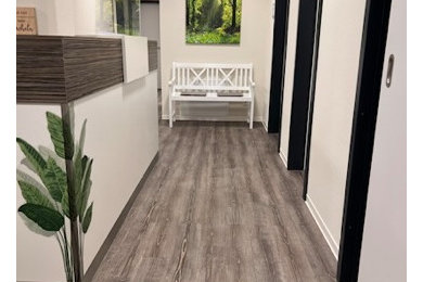 Kleiner Moderner Schmaler Flur mit beiger Wandfarbe, Vinylboden, braunem Boden und Tapetenwänden in Köln