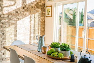 Example of a mid-sized terra-cotta tile and brown floor enclosed dining room design in Other with white walls and no fireplace
