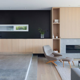 Idee per un soggiorno moderno aperto con sala formale, pareti nere, pavimento in cemento, camino lineare Ribbon e cornice del camino in cemento